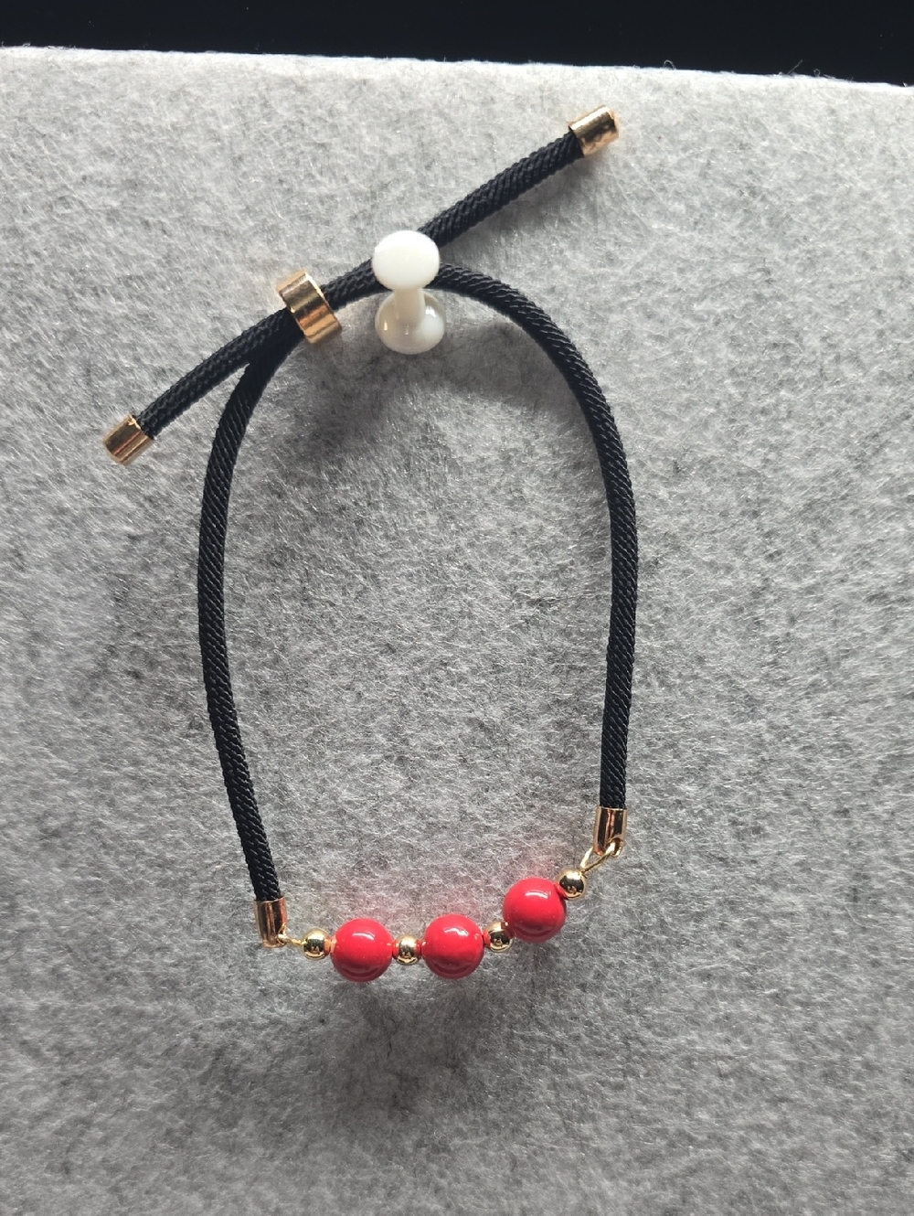 Adjustable Black Cord Bracelet with Red Beads and Gold Accents